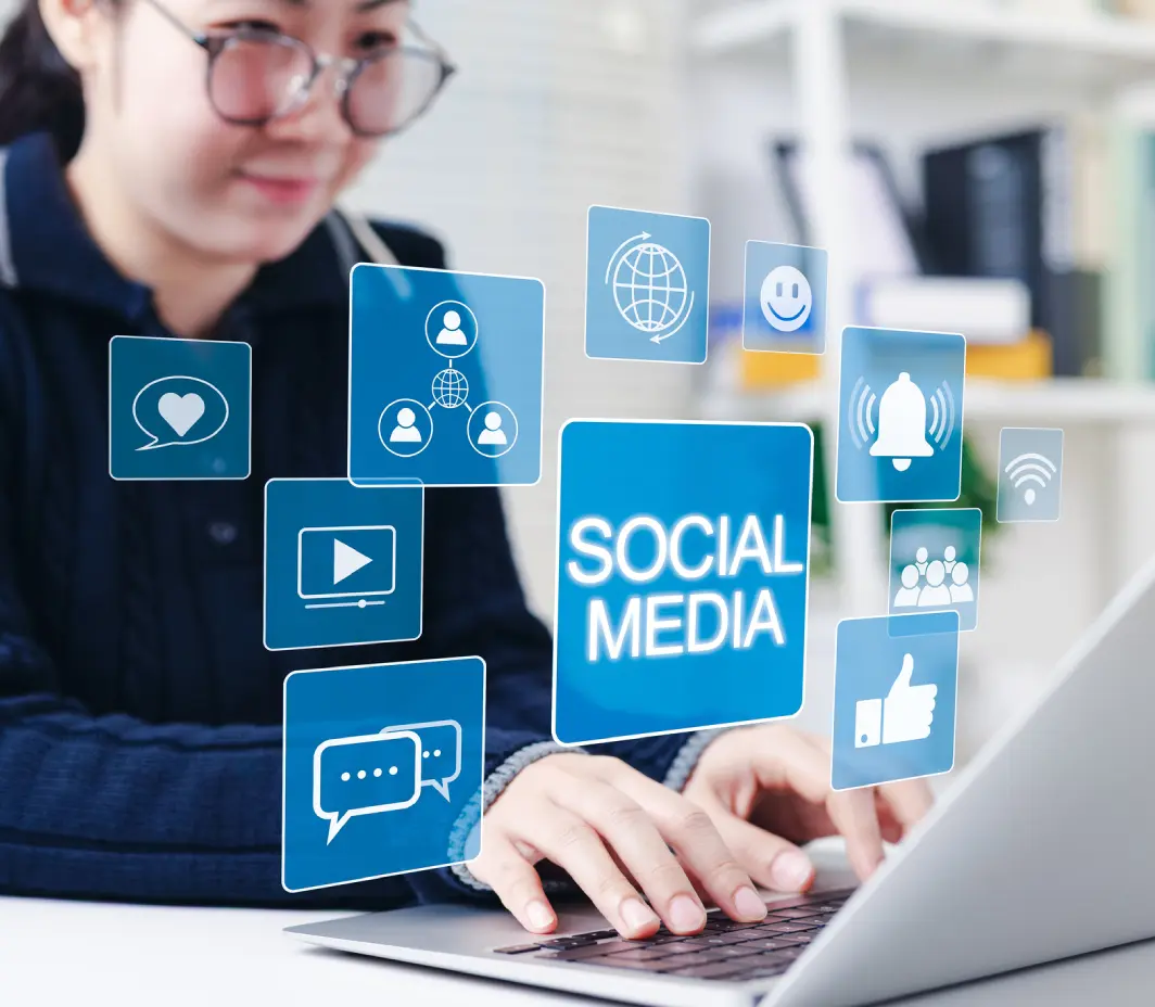 Person using laptop with social media icons.