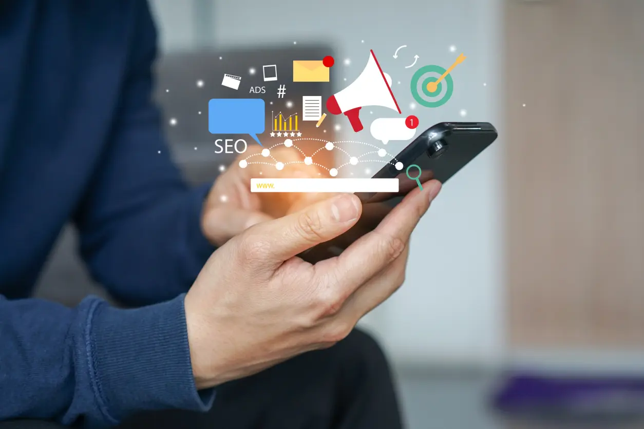 Person using smartphone with digital marketing icons.
